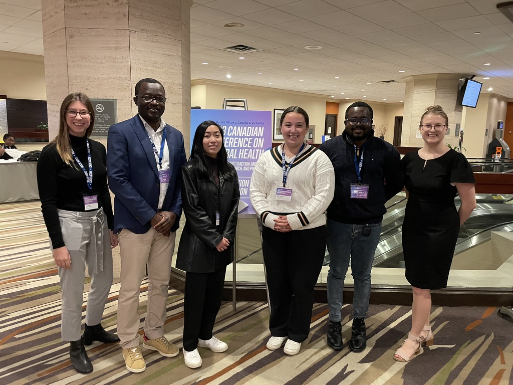 Lab members beside the Canadian Conference on Global Health banner in Ottawa
