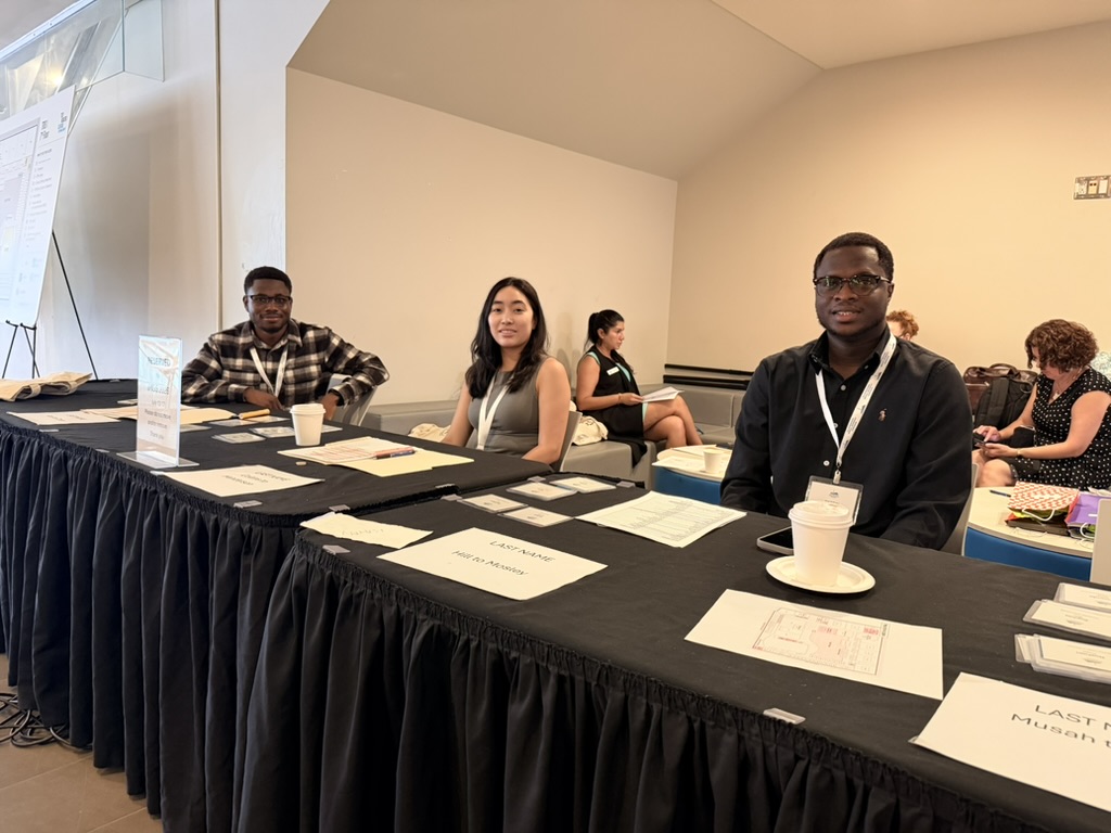 Lab members and other delegates seated at a session table during the symposium